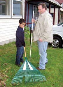 Father and son raking leaves