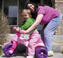 Jo Pinto with her child on a big wheel