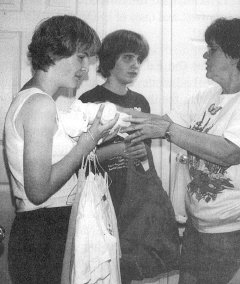 Photo of Pat Jones handing out clean laundry to be put away by her twin granddaughters, Amanda and April. It isn't from a visit.  The girls, who are in the seventh grade at Oolatewah Middle School, have been living with their grandparents for six years.