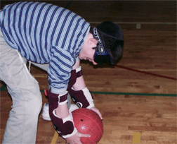 Wing player, Benyamin Waldman, prepares to roll for a goal. Although Waldman is totally blind, goalball rules require that all players wear sleepshades.