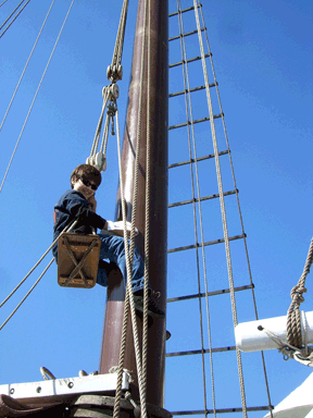 Vejas swabbing the mast of the sailing ship, American Pride, during a class field trip.