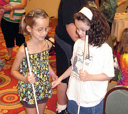 Lindsay (left) and Kendra hold hands as they talk together in NFB Camp