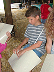 Boy reading Braille on haybail 