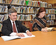 Steve Booth reading a Braille book with Trisha Tatam reading a print book beside him