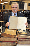 Library Director Morman holding a copy of Louis Braille�s 1829 book that first described the Braille code