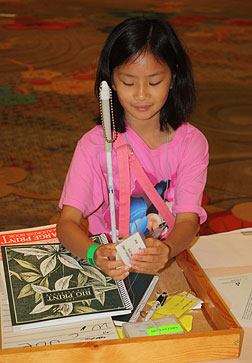 Ahbee Orton of Texas reads a Braille price tag at the NFB store